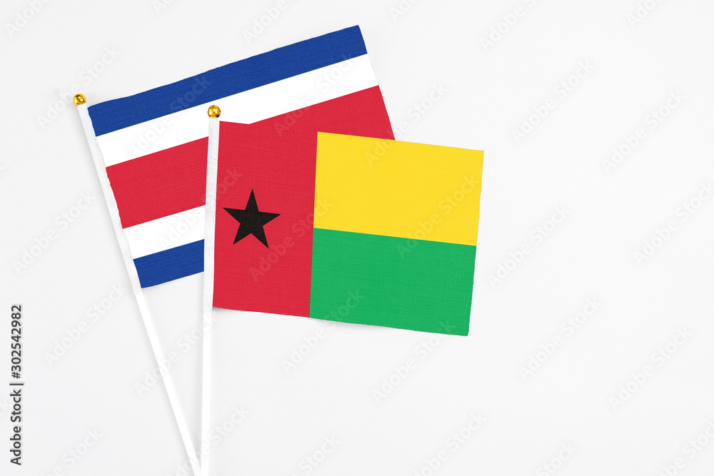 Guinea Bissau and Costa Rica stick flags on white background. High quality fabric, miniature national flag. Peaceful global concept.White floor for copy space. Guinea Bissau and Costa Rica stick flags on white background. High quality fabric, miniature national flag. Peaceful global concept.White floor for copy space.