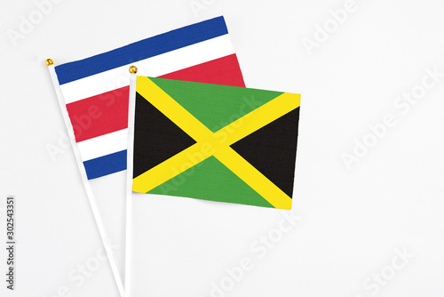 Jamaica and Costa Rica stick flags on white background. High quality fabric  miniature national flag. Peaceful global concept.White floor for copy space.