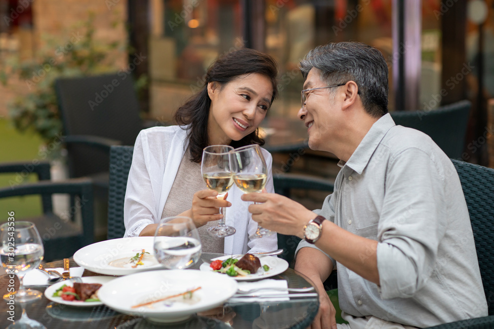 Mature Chinese couple toasting at restaurant Mature Chinese couple toasting at restaurant