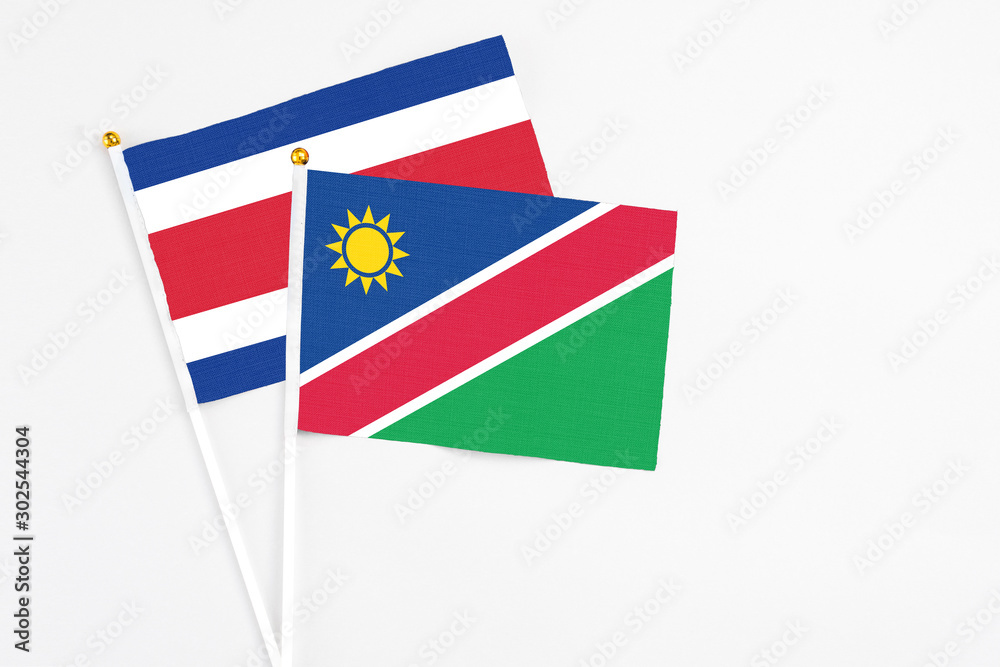 Namibia and Costa Rica stick flags on white background. High quality fabric, miniature national flag. Peaceful global concept.White floor for copy space.