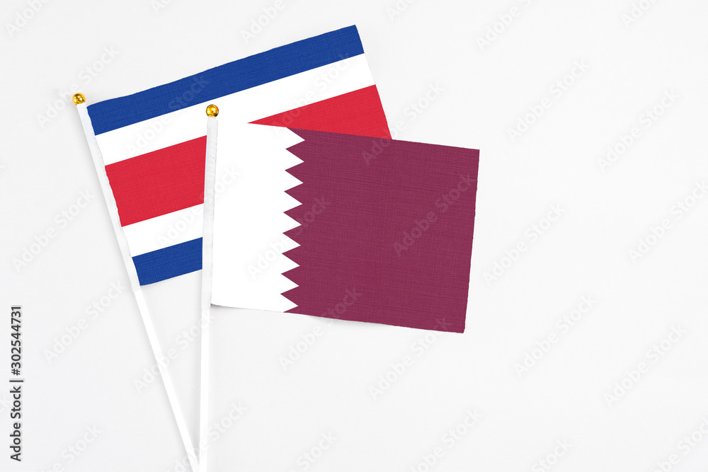 Qatar and Costa Rica stick flags on white background. High quality fabric, miniature national flag. Peaceful global concept.White floor for copy space. Qatar and Costa Rica stick flags on white background. High quality fabric, miniature national flag. Peaceful global concept.White floor for copy space.