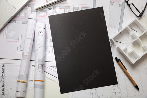 Construction concept. Residential building blueprint drawings and office supplies