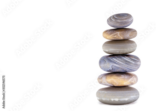 Pile of spa stones on the table against a white background  space for text. Zen stones for meditation and mystical healing.