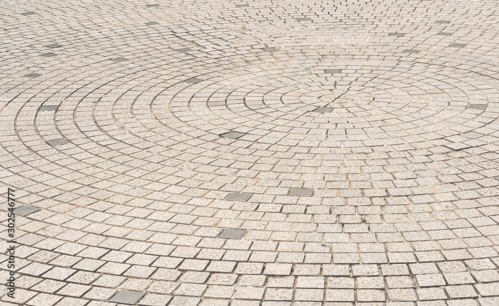 Circle stone tile floor design for footpath in center of urban park, street city exterior background Circle stone tile floor design for footpath in center of urban park, street city exterior background