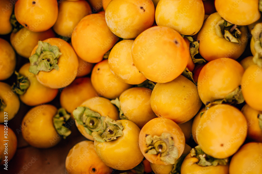  ripe tasty orange persimmon on the food market