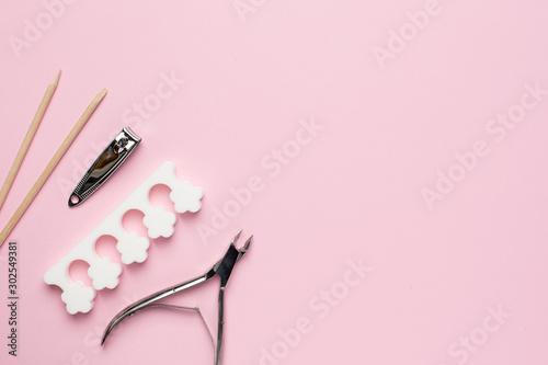 Manicure and pedicure tools on pink background with copyspace , nail care set