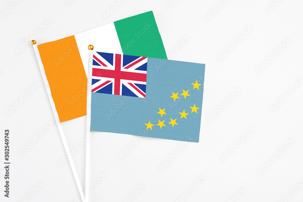 Fototapeta premium Tuvalu and Cote D'Ivoire stick flags on white background. High quality fabric, miniature national flag. Peaceful global concept.White floor for copy space.