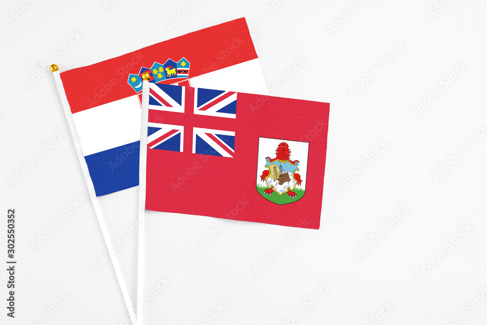 Fototapeta premium Bermuda and Croatia stick flags on white background. High quality fabric, miniature national flag. Peaceful global concept.White floor for copy space.
