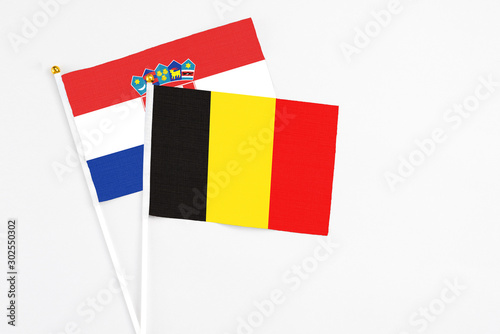 Belgium and Croatia stick flags on white background. High quality fabric, miniature national flag. Peaceful global concept.White floor for copy space. photo