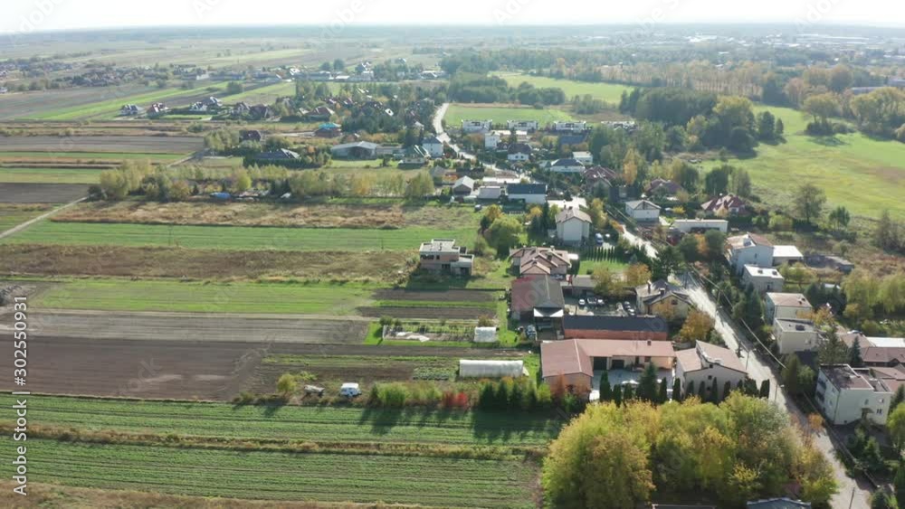 Aerial view of a village in a suburb of Warsaw. Drone shot over the red roofs in an idyllic suburban town on a sunny summer day. Row houses with green lawns. Drone Shot 4K. Aerial view of a village in a suburb of Warsaw. Drone shot over the red roofs in an idyllic suburban town on a sunny summer day. Row houses with green lawns. Drone Shot 4K.