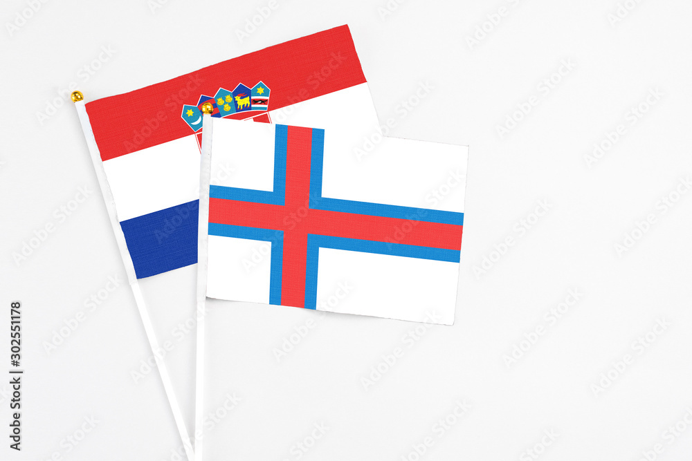 Faroe Islands and Croatia stick flags on white background. High quality fabric, miniature national flag. Peaceful global concept.White floor for copy space.