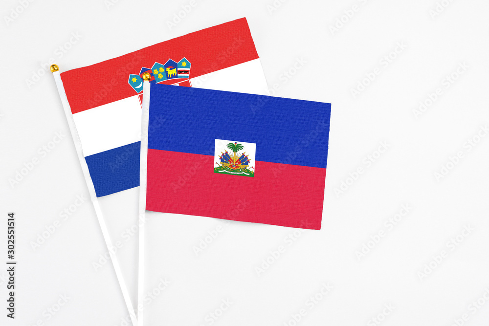 Haiti and Croatia stick flags on white background. High quality fabric, miniature national flag. Peaceful global concept.White floor for copy space. Haiti and Croatia stick flags on white background. High quality fabric, miniature national flag. Peaceful global concept.White floor for copy space.