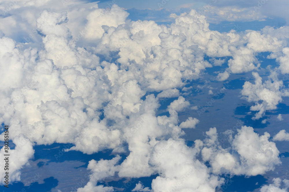 clusters of white clouds visible from above in the sky clusters of white clouds visible from above in the sky