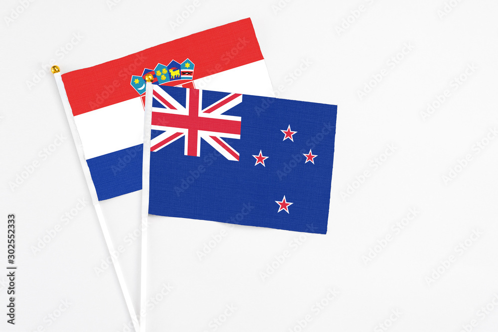Fototapeta premium New Zealand and Croatia stick flags on white background. High quality fabric, miniature national flag. Peaceful global concept.White floor for copy space.