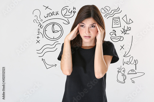 Stressed young woman on light background