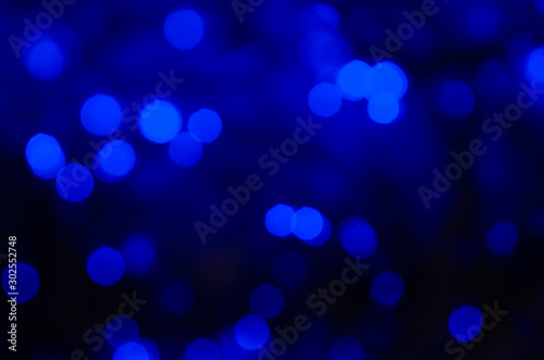 Abstract bokeh of neon blue lights on a dark background