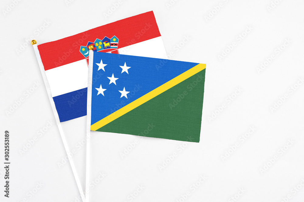 Solomon Islands and Croatia stick flags on white background. High quality fabric, miniature national flag. Peaceful global concept.White floor for copy space.