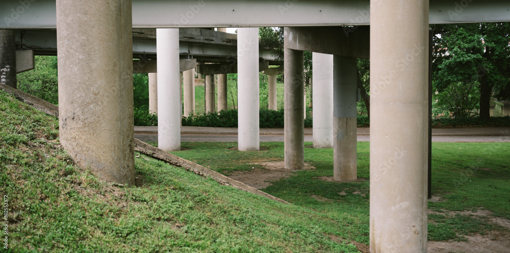 Grassy area and road underneath highway overpass Grassy area and road underneath highway overpass