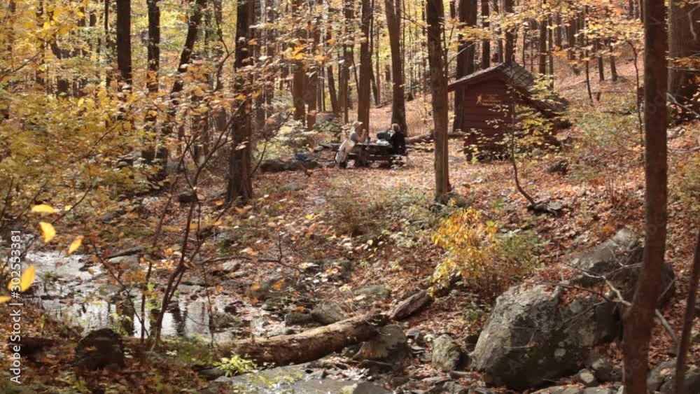 Two hikers eat lunch at picnic table, Harpers Creek shelter
