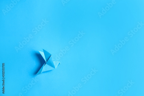 Origami bird on color backg...