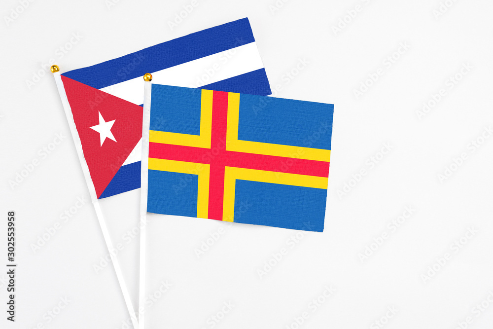 Aland Islands and Cuba stick flags on white background. High quality fabric, miniature national flag. Peaceful global concept.White floor for copy space. Aland Islands and Cuba stick flags on white background. High quality fabric, miniature national flag. Peaceful global concept.White floor for copy space.