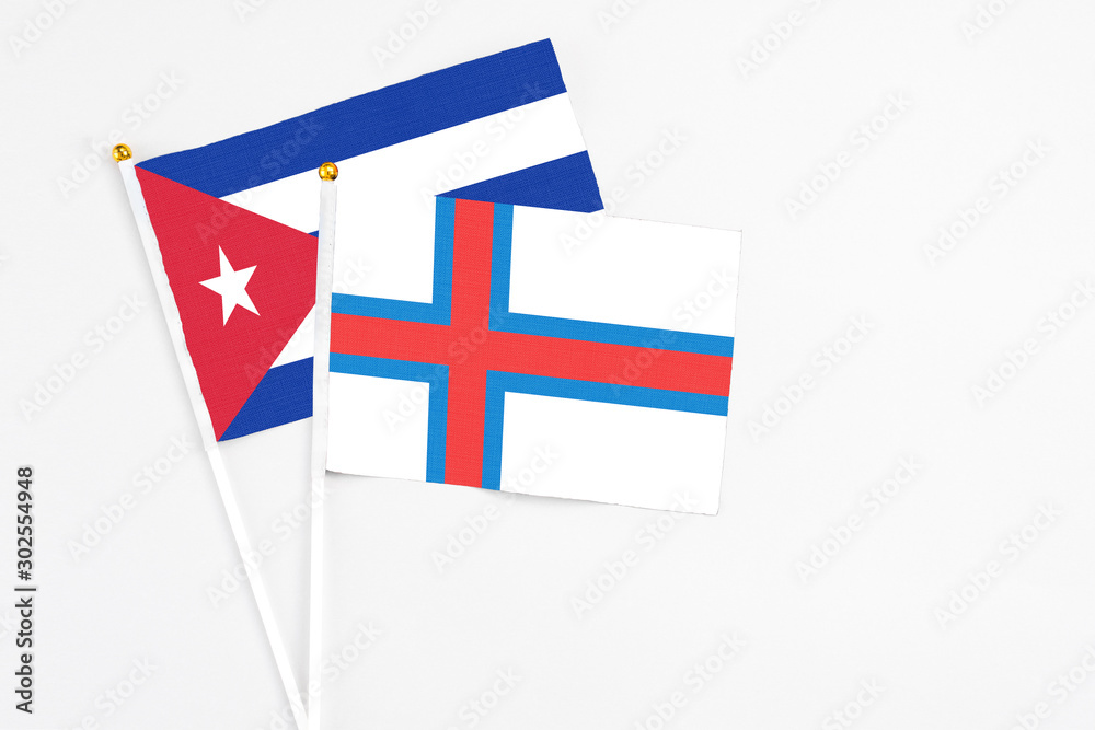 Faroe Islands and Cuba stick flags on white background. High quality fabric, miniature national flag. Peaceful global concept.White floor for copy space.