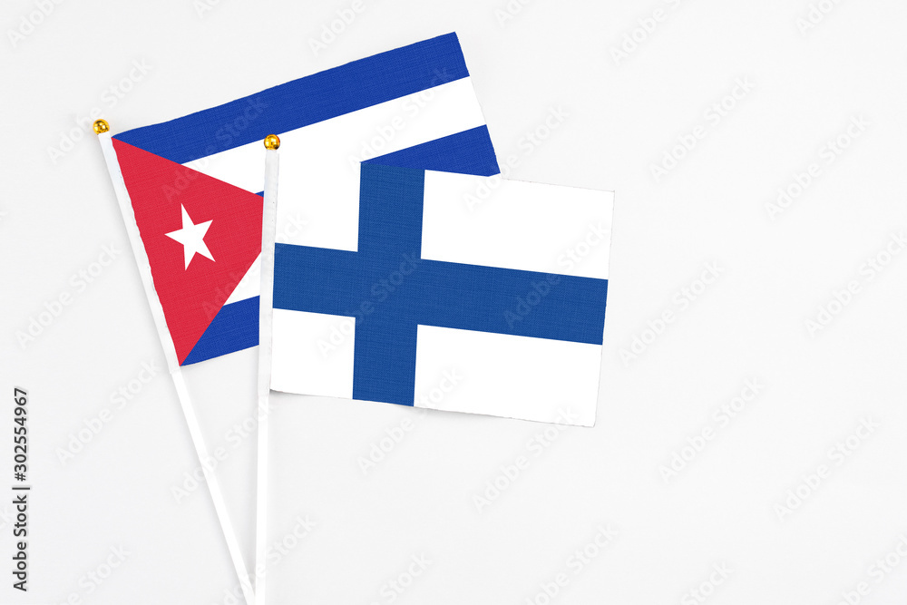 Finland and Cuba stick flags on white background. High quality fabric, miniature national flag. Peaceful global concept.White floor for copy space.