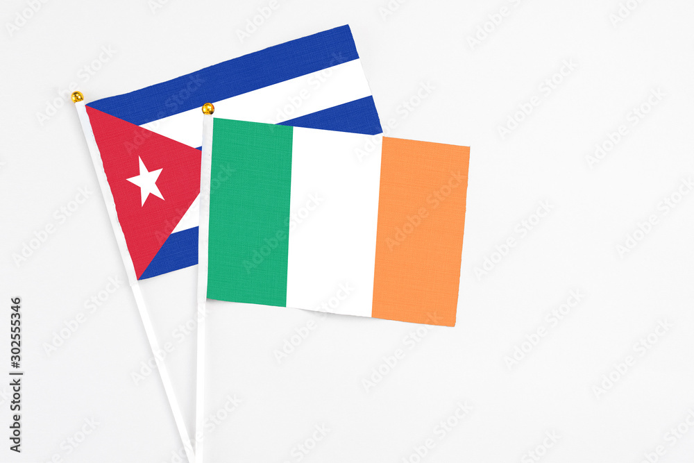 Ireland and Cuba stick flags on white background. High quality fabric, miniature national flag. Peaceful global concept.White floor for copy space. Ireland and Cuba stick flags on white background. High quality fabric, miniature national flag. Peaceful global concept.White floor for copy space.