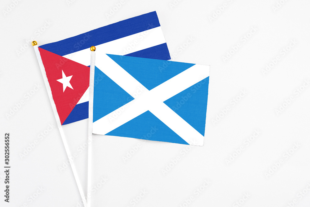 Scotland and Cuba stick flags on white background. High quality fabric, miniature national flag. Peaceful global concept.White floor for copy space. Scotland and Cuba stick flags on white background. High quality fabric, miniature national flag. Peaceful global concept.White floor for copy space.