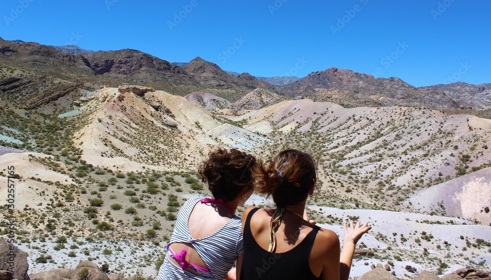 Two girls contemplating the colorful mountains