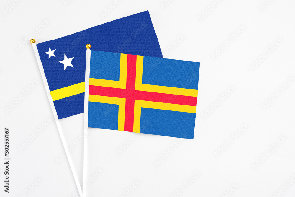 Aland Islands and Curacao stick flags on white background. High quality fabric, miniature national flag. Peaceful global concept.White floor for copy space.