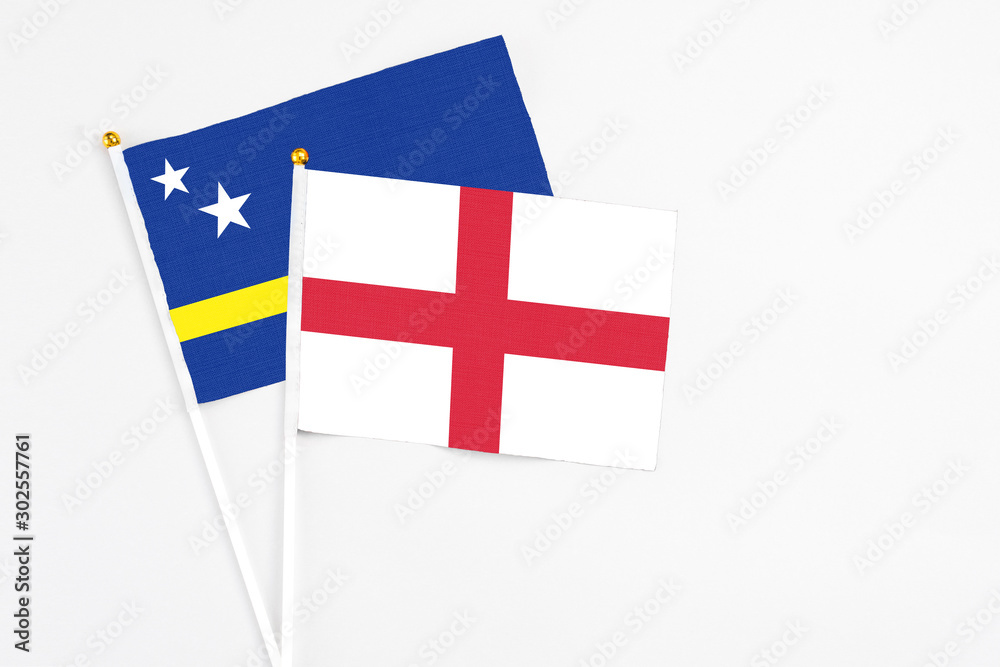 England and Curacao stick flags on white background. High quality fabric, miniature national flag. Peaceful global concept.White floor for copy space.