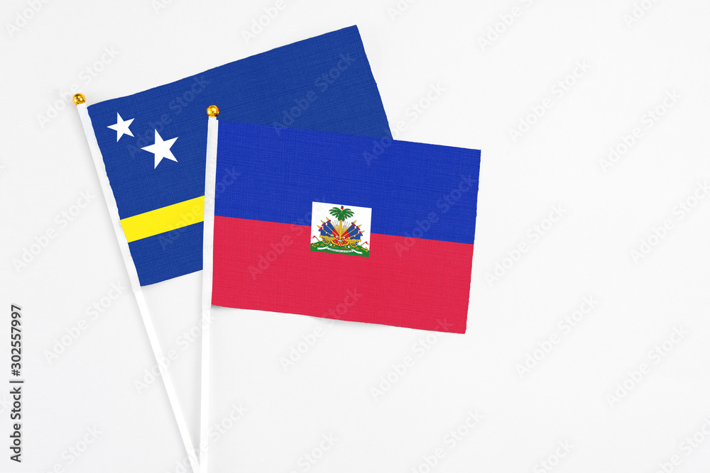 Haiti and Curacao stick flags on white background. High quality fabric, miniature national flag. Peaceful global concept.White floor for copy space. Haiti and Curacao stick flags on white background. High quality fabric, miniature national flag. Peaceful global concept.White floor for copy space.