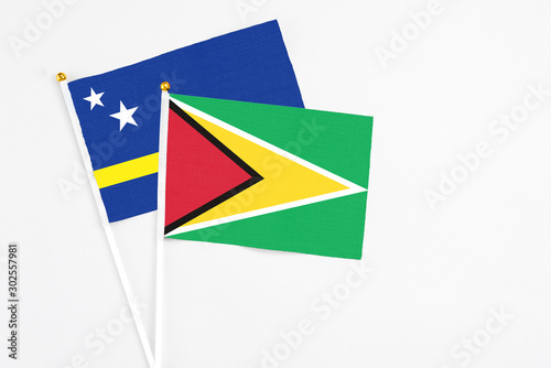 Free Download Guyana and Curacao stick flags on white background. High quality fabric, miniature national flag. Peaceful global concept.White floor for copy space. - GFXLoad