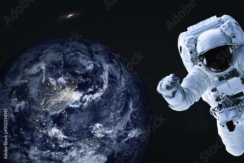 Astronaut near night Earth planet of solar system Closeup. Outer space journy. Science fiction. Elements of the image were furnished by NASA photo
