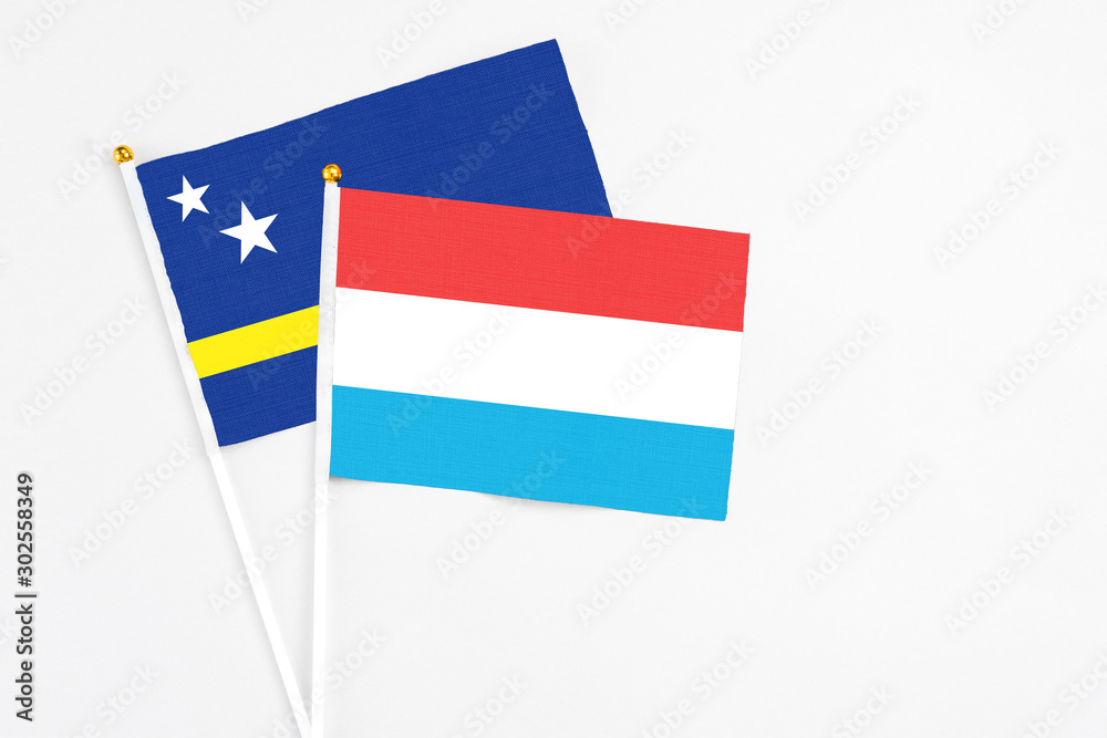 Luxembourg and Curacao stick flags on white background. High quality fabric, miniature national flag. Peaceful global concept.White floor for copy space. Luxembourg and Curacao stick flags on white background. High quality fabric, miniature national flag. Peaceful global concept.White floor for copy space.