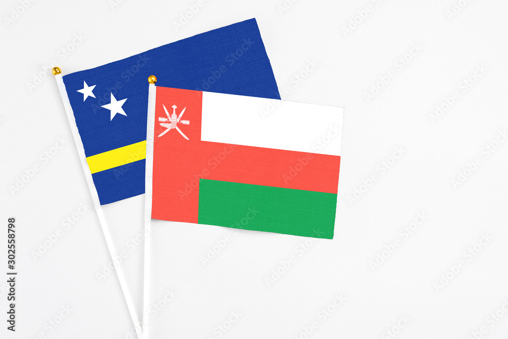 Oman and Curacao stick flags on white background. High quality fabric, miniature national flag. Peaceful global concept.White floor for copy space. Oman and Curacao stick flags on white background. High quality fabric, miniature national flag. Peaceful global concept.White floor for copy space.