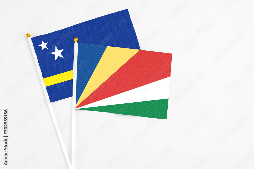 Seychelles and Curacao stick flags on white background. High quality fabric, miniature national flag. Peaceful global concept.White floor for copy space. Seychelles and Curacao stick flags on white background. High quality fabric, miniature national flag. Peaceful global concept.White floor for copy space.