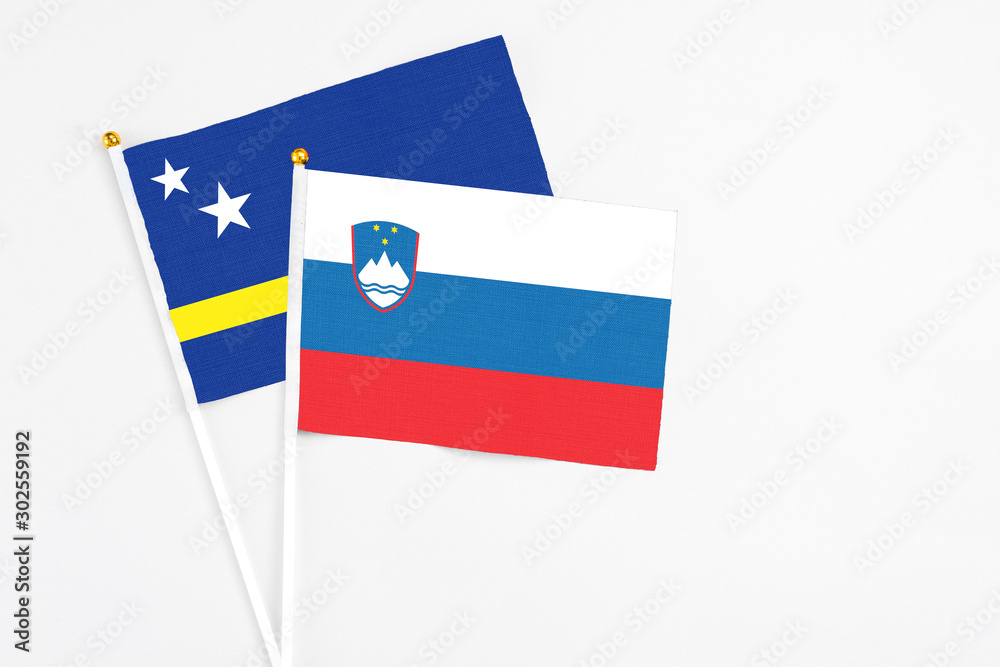 Slovenia and Curacao stick flags on white background. High quality fabric, miniature national flag. Peaceful global concept.White floor for copy space. Slovenia and Curacao stick flags on white background. High quality fabric, miniature national flag. Peaceful global concept.White floor for copy space.