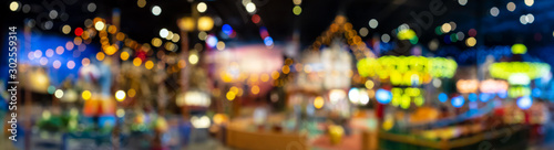 Beautiful blurry and defocused multicolored lights of the carousel in the night park. Panorama. photo