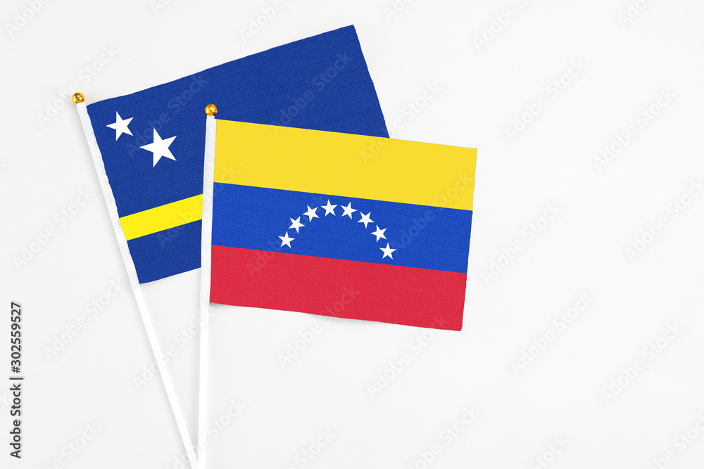 Venezuela and Curacao stick flags on white background. High quality fabric, miniature national flag. Peaceful global concept.White floor for copy space. Venezuela and Curacao stick flags on white background. High quality fabric, miniature national flag. Peaceful global concept.White floor for copy space.