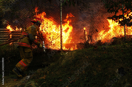 a fireman puts out a forest fire