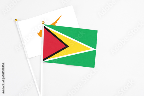 Guyana and Cyprus stick flags on white background. High quality fabric  miniature national flag. Peaceful global concept.White floor for copy space.