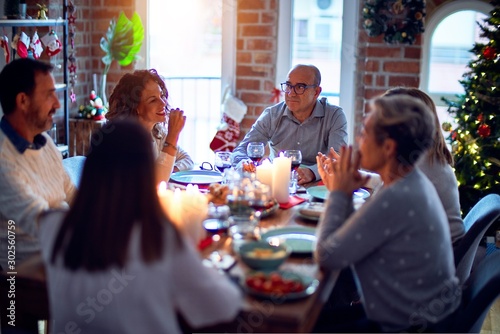 Fotografie Family and friends dining at home celebrating christmas eve with traditional foo