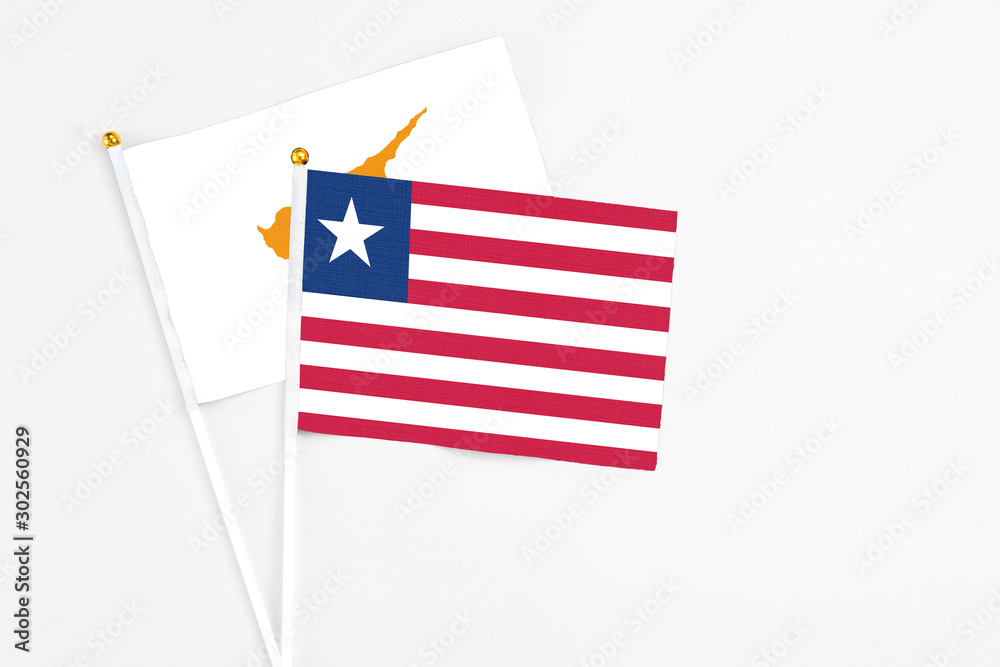 Liberia and Cyprus stick flags on white background. High quality fabric, miniature national flag. Peaceful global concept.White floor for copy space. Liberia and Cyprus stick flags on white background. High quality fabric, miniature national flag. Peaceful global concept.White floor for copy space.