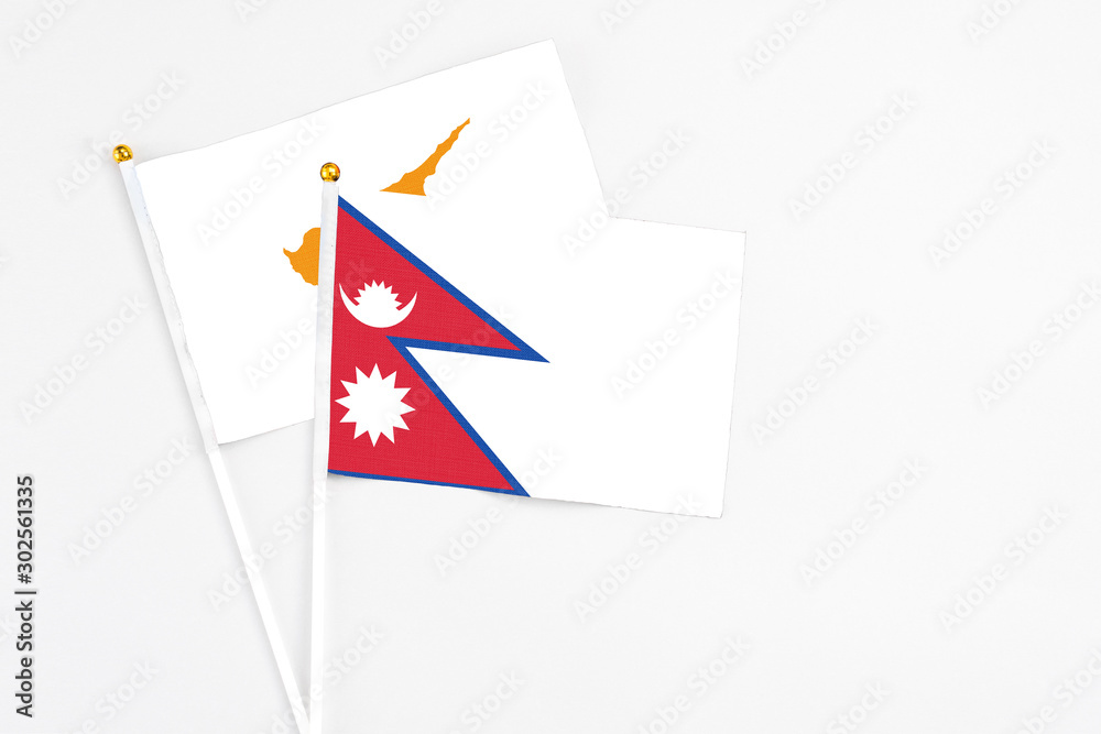Obraz premium Nepal and Cyprus stick flags on white background. High quality fabric, miniature national flag. Peaceful global concept.White floor for copy space.