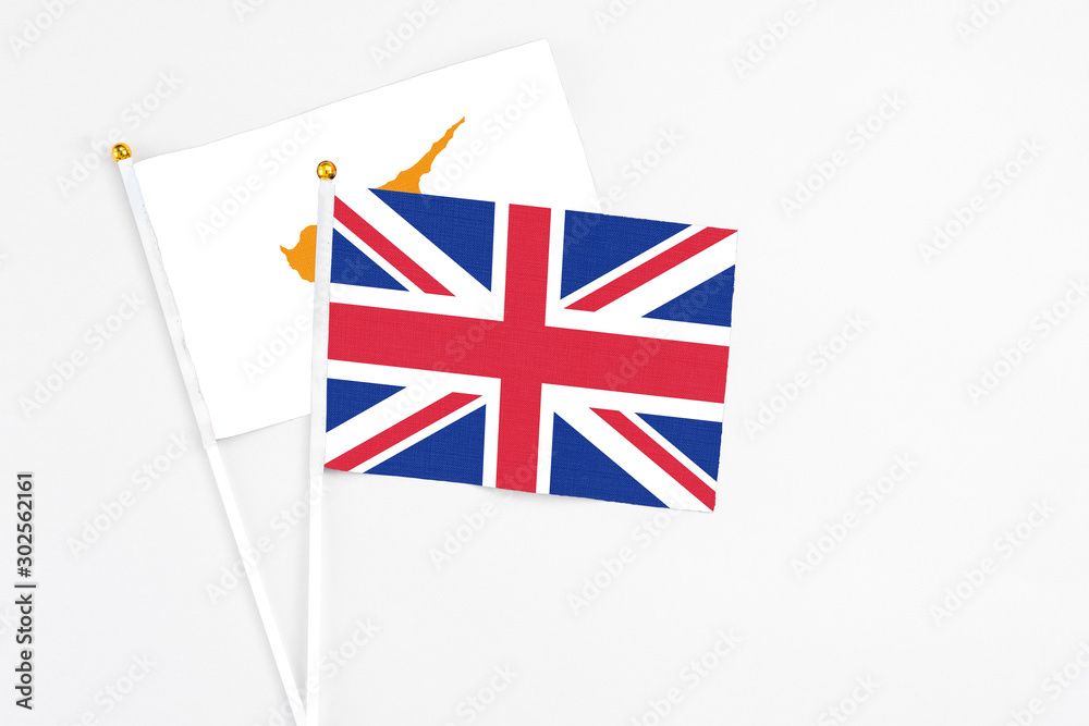 United Kingdom and Cyprus stick flags on white background. High quality fabric, miniature national flag. Peaceful global concept.White floor for copy space. United Kingdom and Cyprus stick flags on white background. High quality fabric, miniature national flag. Peaceful global concept.White floor for copy space.