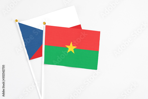 Burkina Faso and Cyprus stick flags on white background. High quality fabric, miniature national flag. Peaceful global concept.White floor for copy space.
