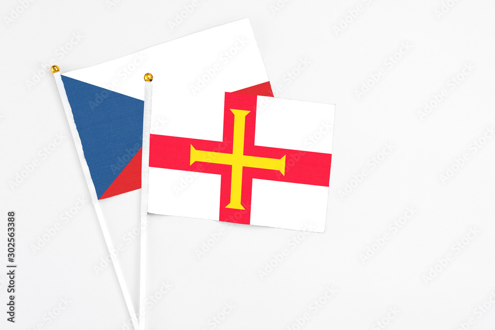 Guernsey and Cyprus stick flags on white background. High quality fabric, miniature national flag. Peaceful global concept.White floor for copy space.