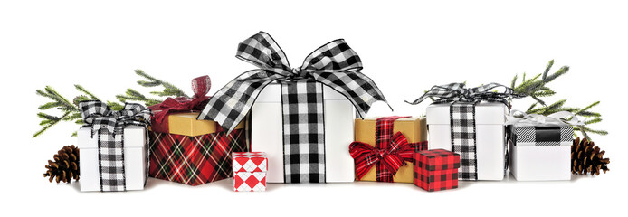 Assortment of many Christmas gift boxes with plaid wrap and ribbon and tree branches isolated on a white background